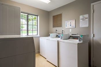 a laundry room with four washers and dryers